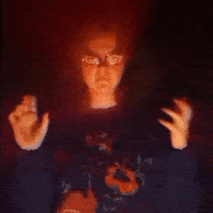 a girl Agatha standing in the dark room with a straight face, shaking her hands in the air